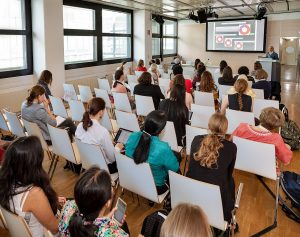 A group of diverse women in a meeting discussing ideas.