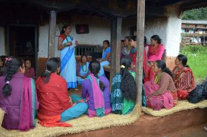 A group of diverse women discussing and supporting each other in a community setting.
